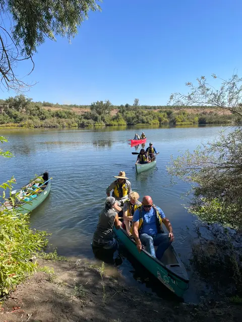 Families loading canoes at the water's edge