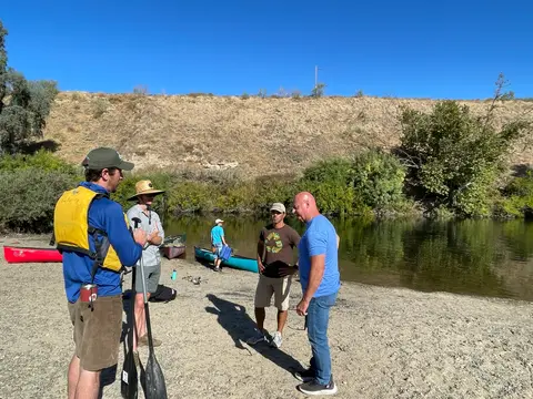 Volunteers talking through the day's plan on the riverbank